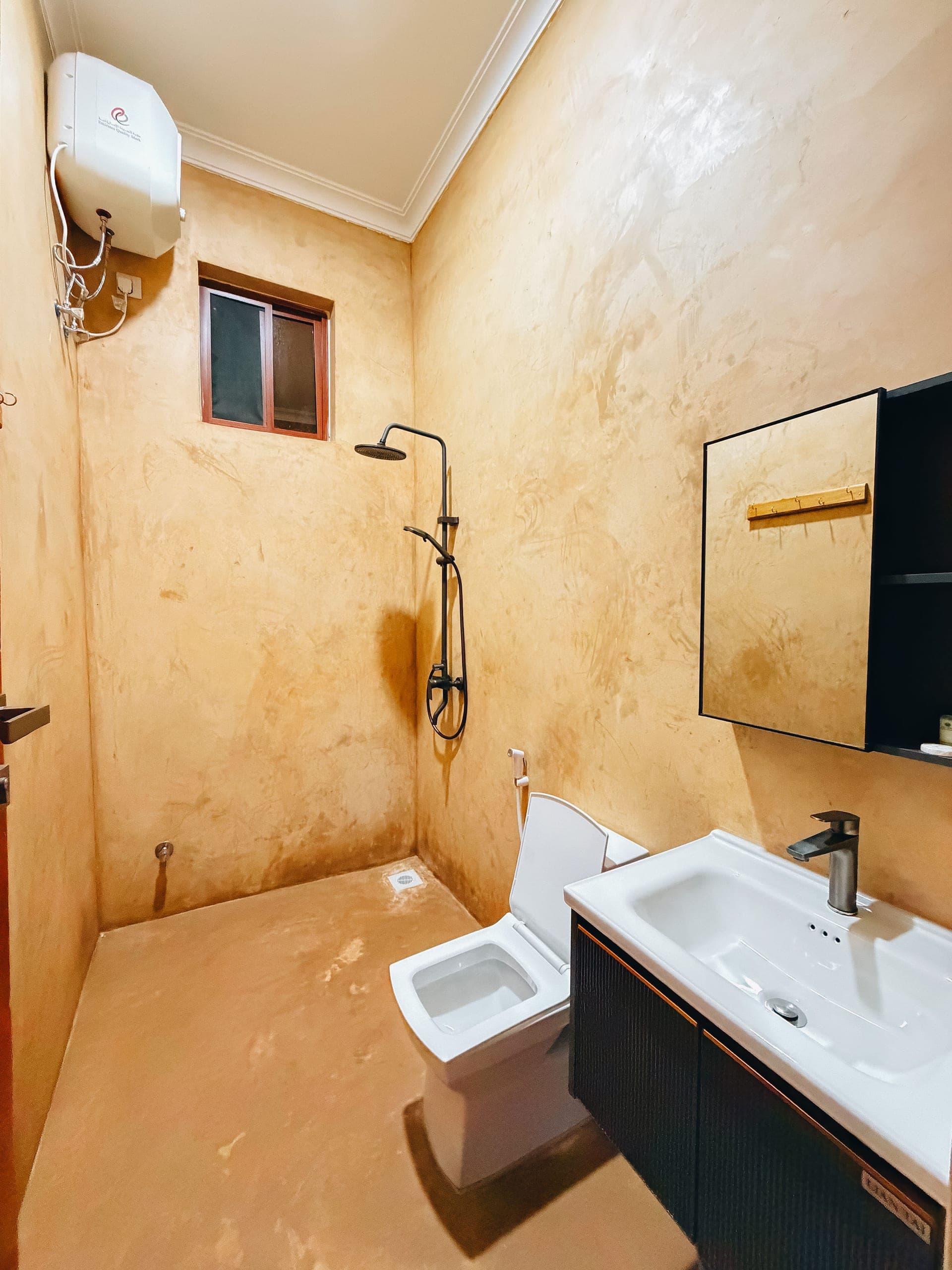 Private bathroom with a rain shower, polished ochre plaster walls, toilet and vanity
