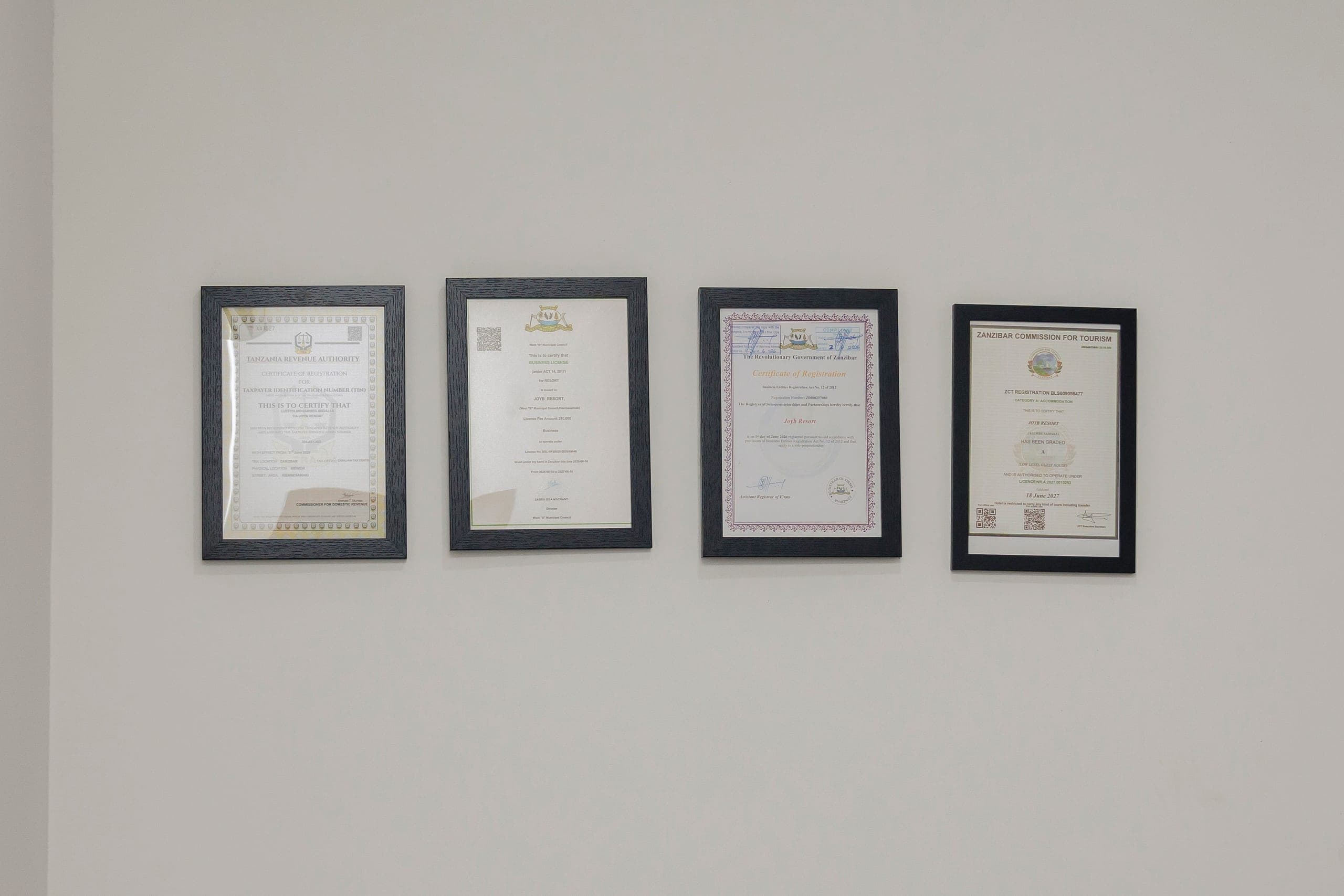 Framed JoyB Resort certificates displayed on a wall