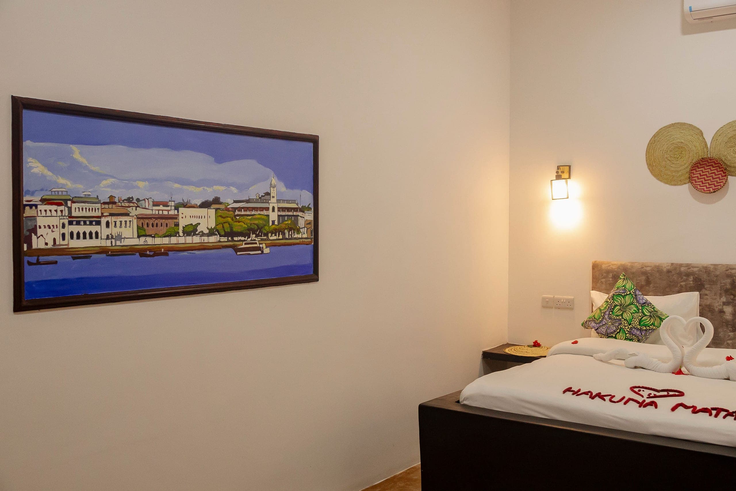 Framed painting of the Stone Town waterfront on the bedroom wall