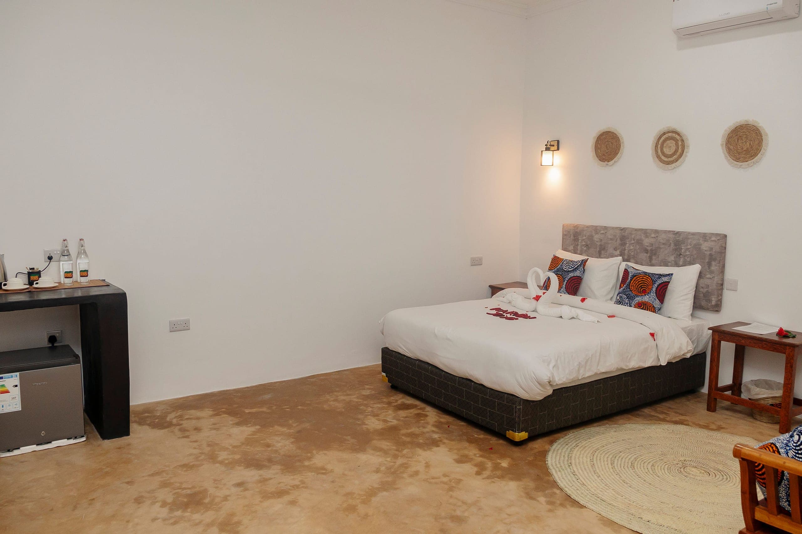 The full length of the deluxe room, with a tea and coffee console and a mini fridge