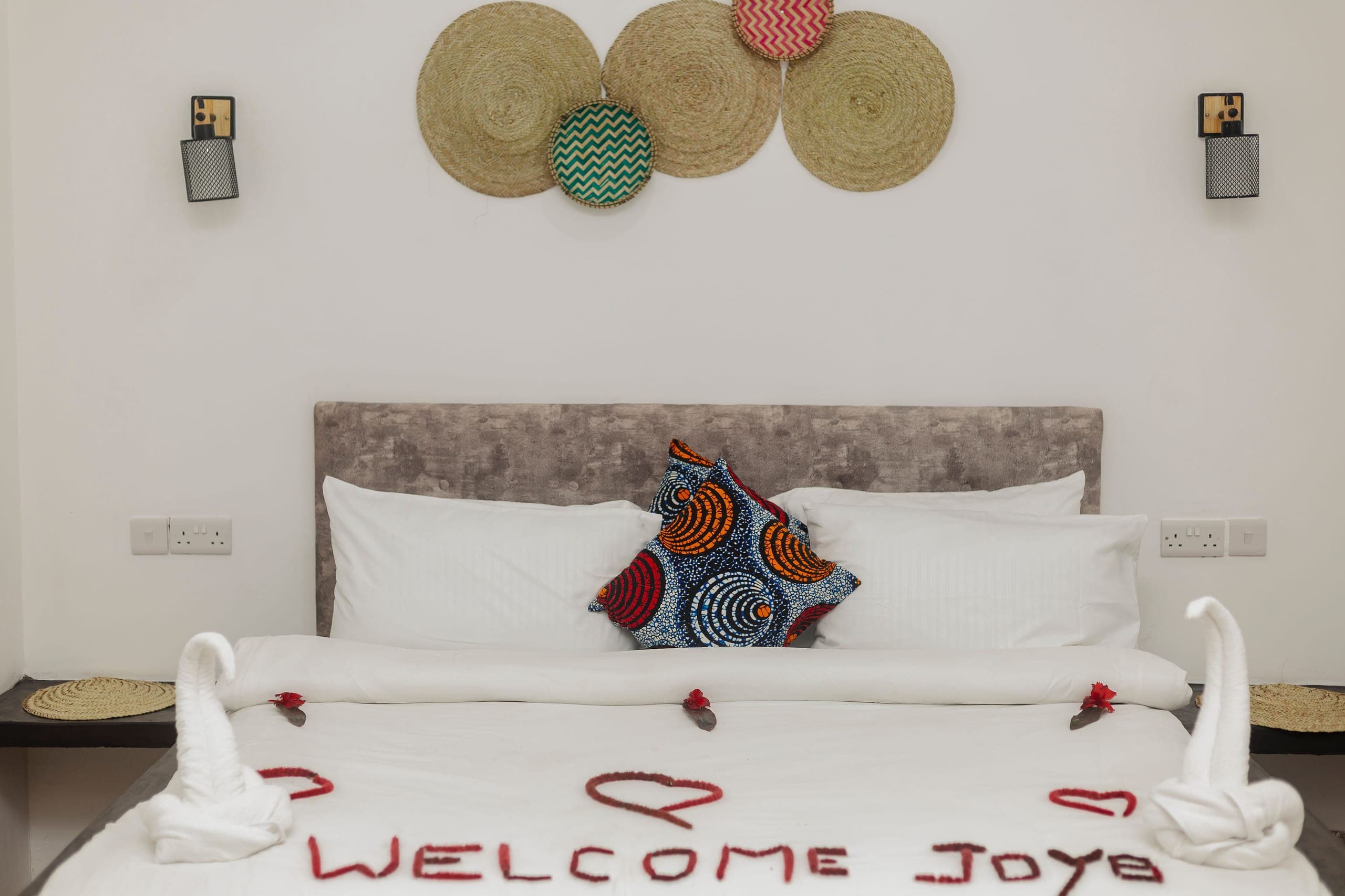 Bed turned down with a petal welcome message and towel swans