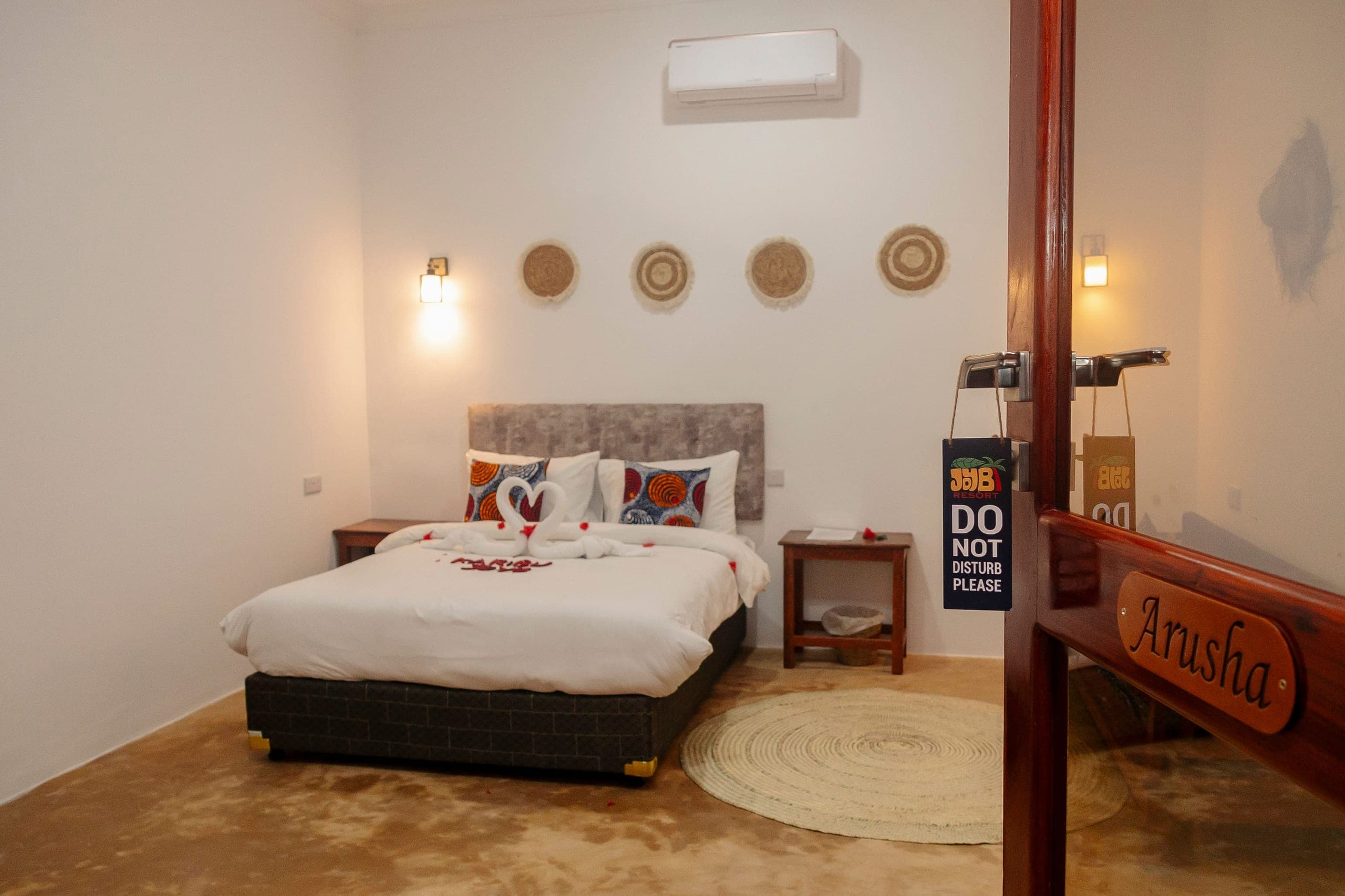 The double room seen from the doorway, bed turned down with petals