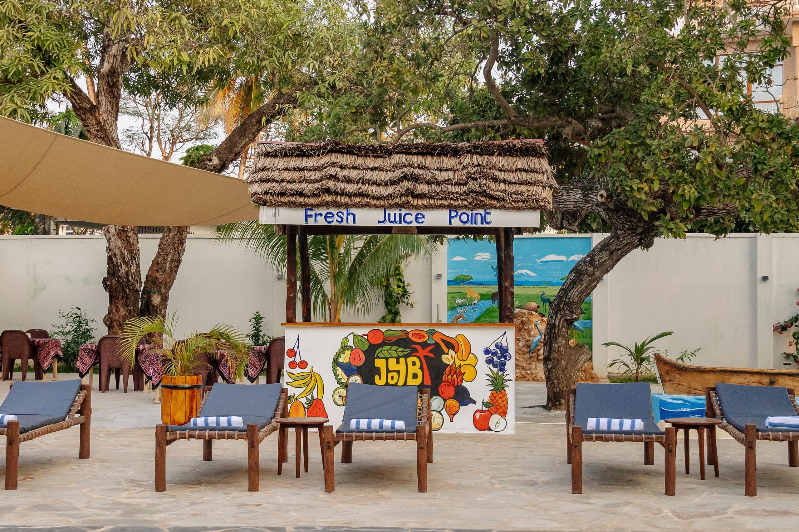 The Fresh Juice Point counter painted with fruit, sun loungers in front