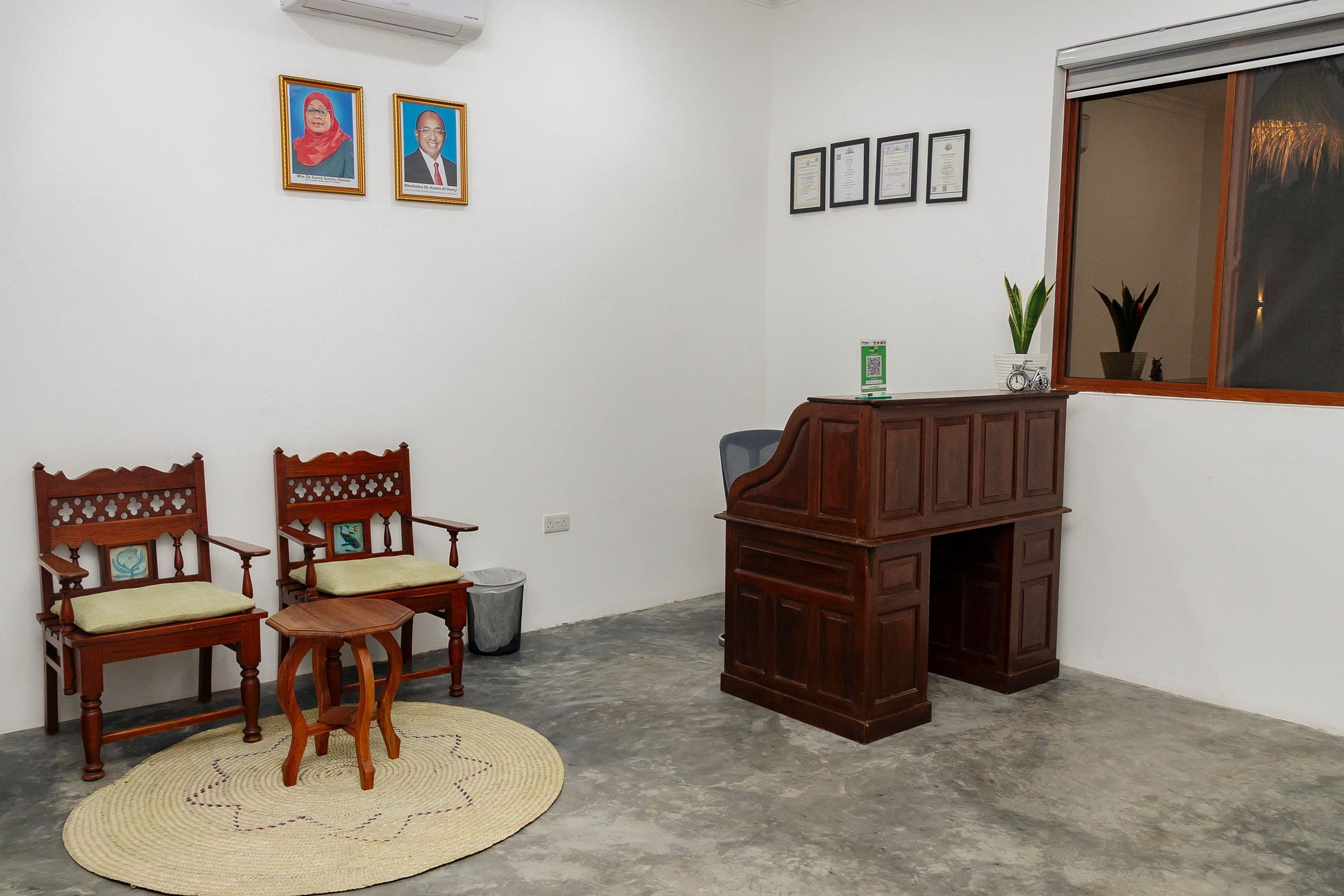 The reception desk at JoyB, a carved wooden bureau with two Zanzibari chairs beside it