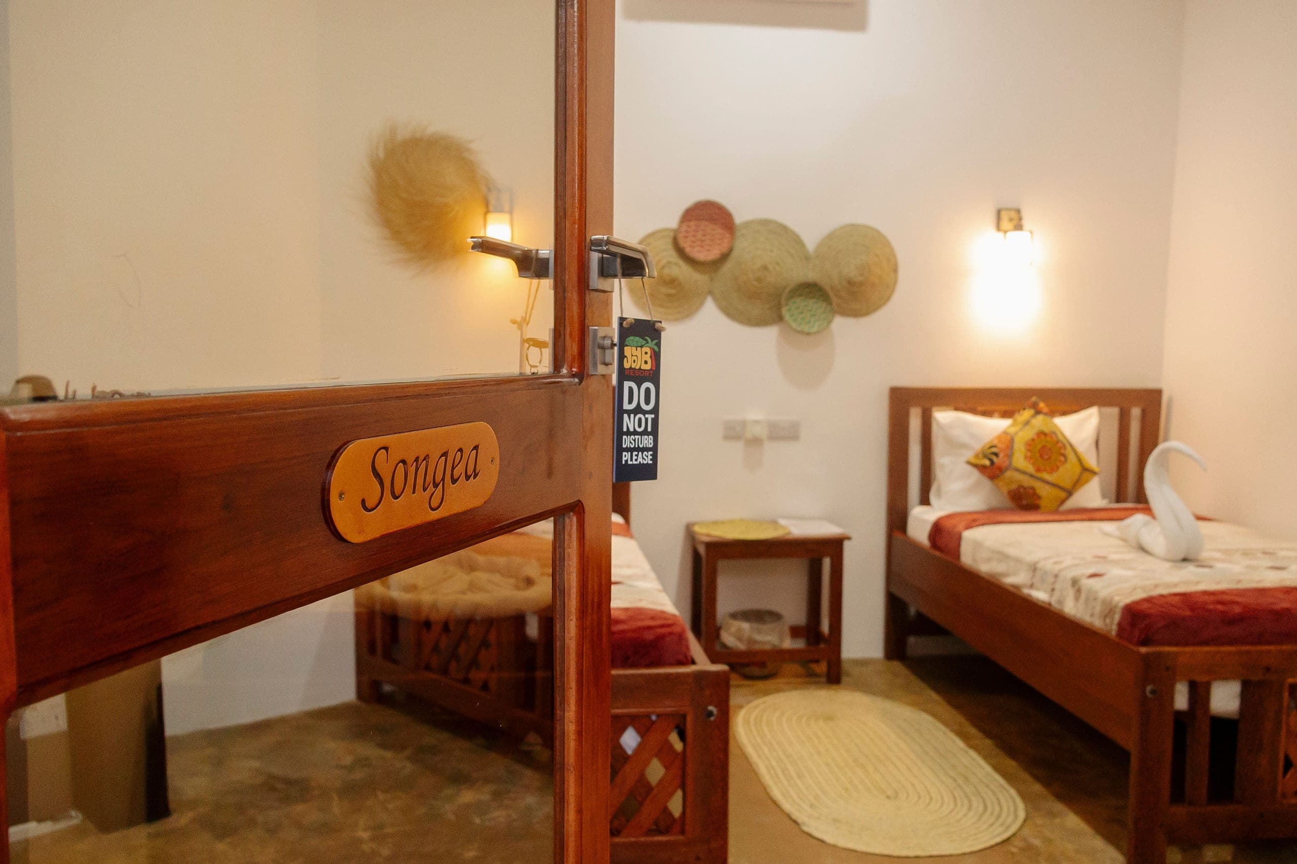 The twin room seen through its doorway, name plate on the open door